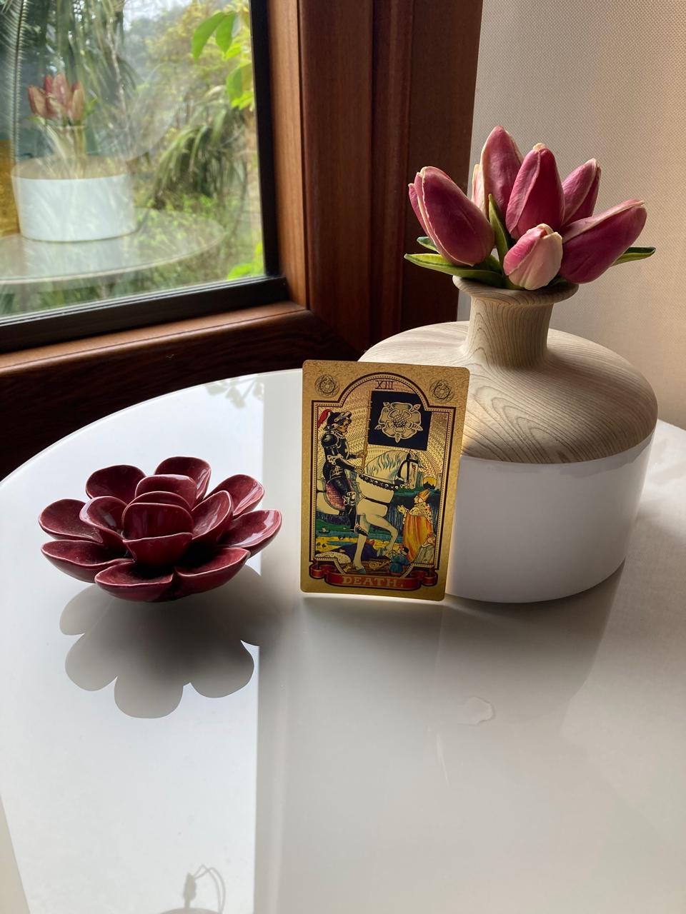 Carta de tarot na janela com flores